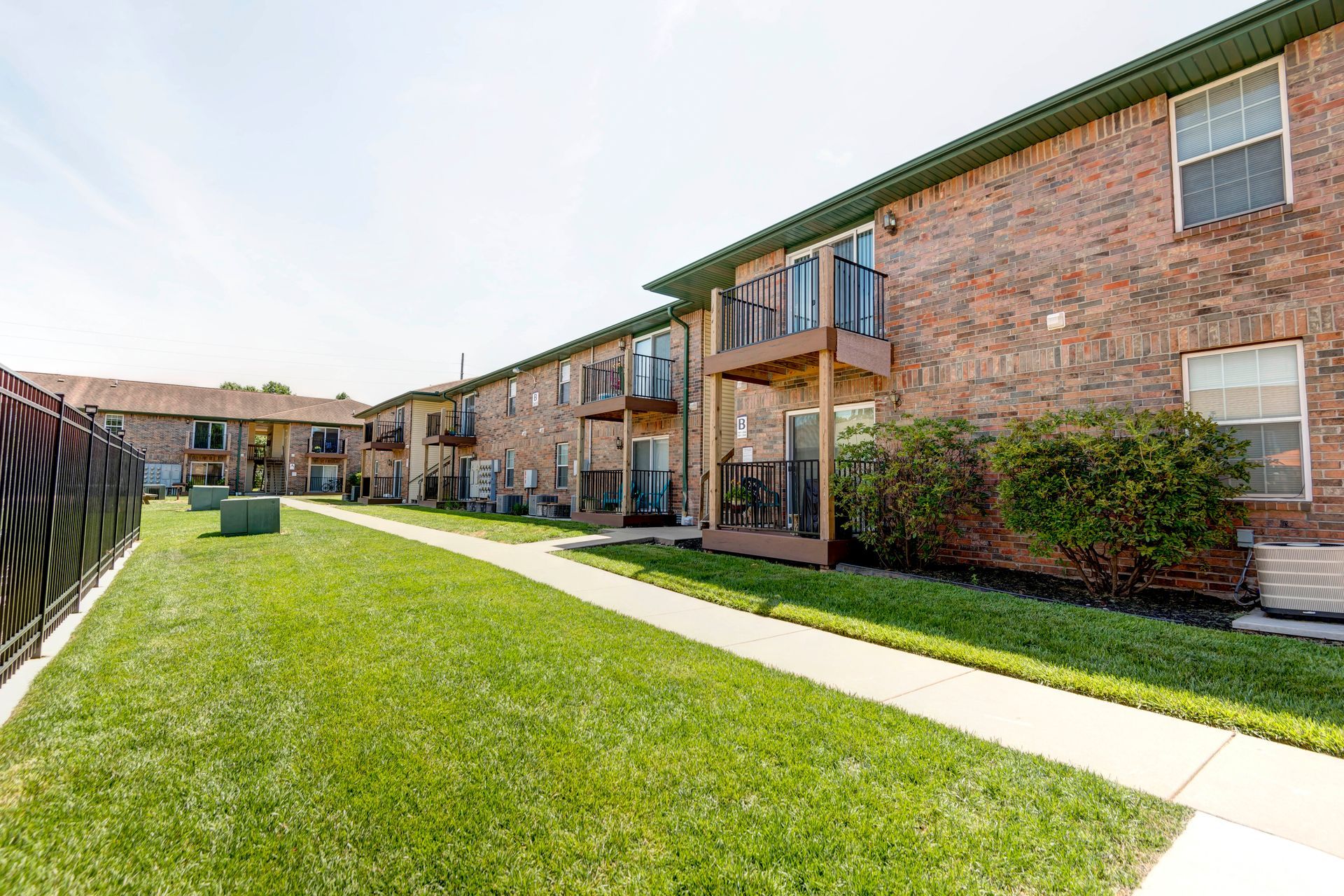 Photo of the courtyard area with a paved path leading to apartment entrances