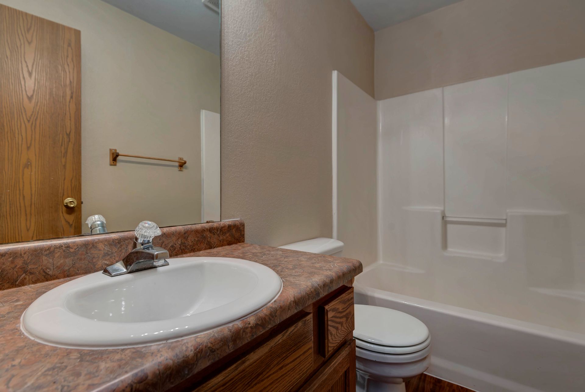 Photo of a bathroom with a shower/bathtub combo in the background