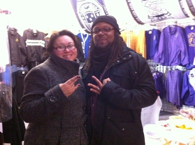 A man and a woman are posing for a picture in front of a store