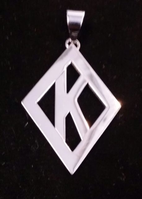 A diamond shaped pendant with the letter k on it