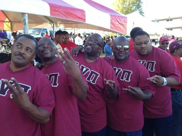 A group of men wearing red shirts with the letter v on them