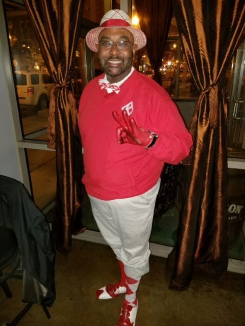 A man wearing a red shirt with the letter t on it