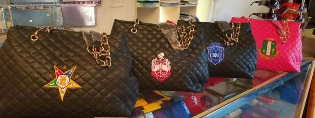 A row of handbags sitting on top of a glass display case.