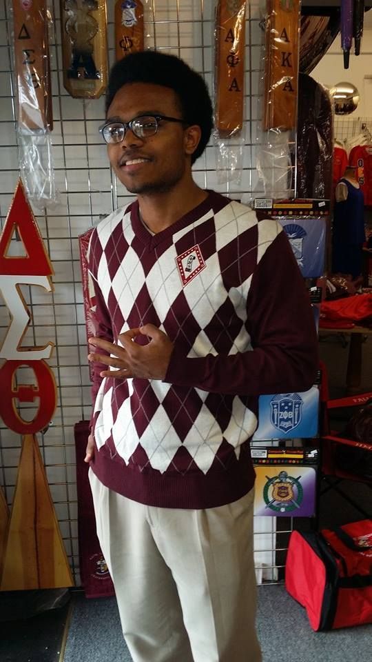 A man wearing a maroon and white argyle sweater
