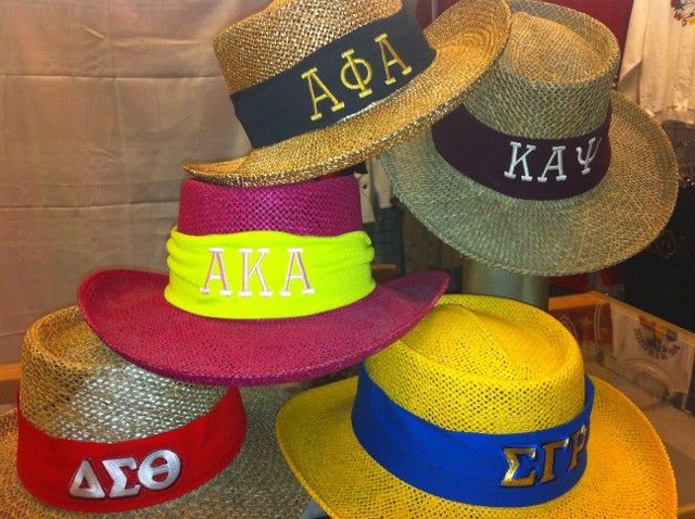 Several hats are stacked on top of each other including one that says aka
