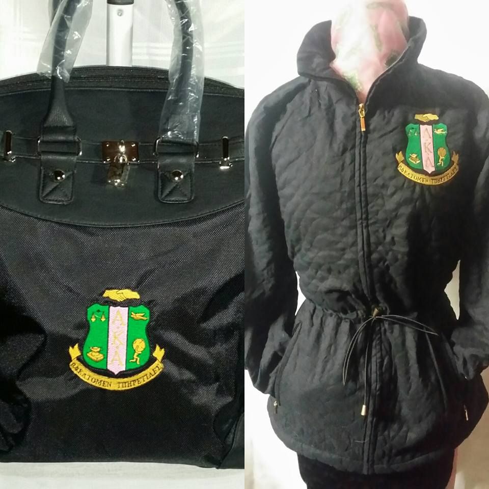 A black purse and a black jacket with a crest on them