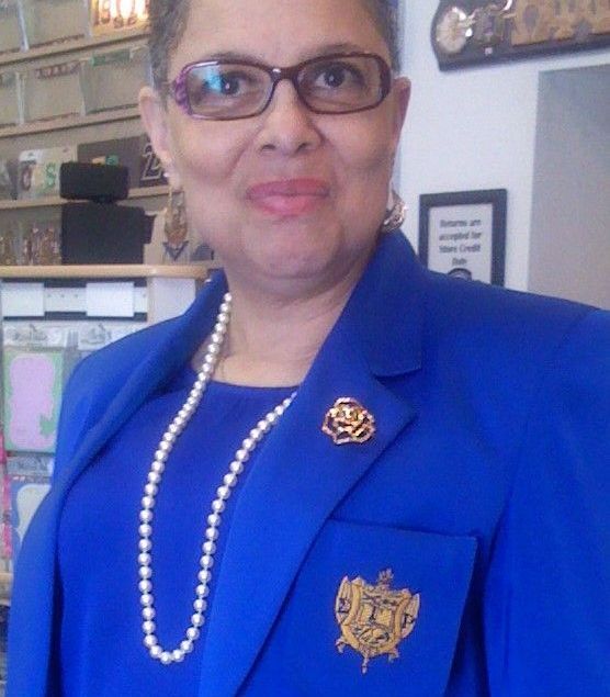A woman wearing glasses and a blue jacket