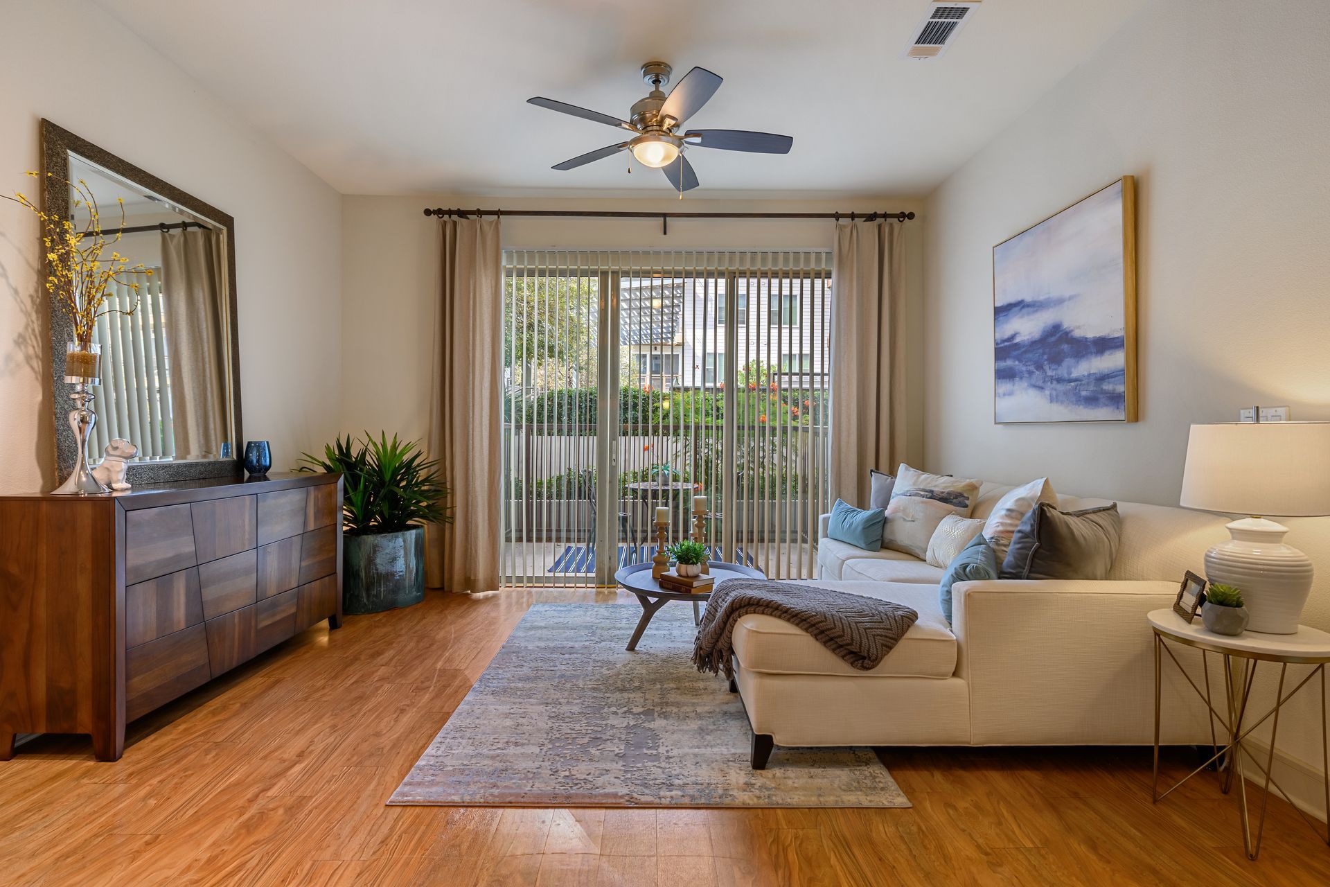 Living room with couch, coffee table, rug, and sliding glass door to a patio at Sabina in Central Austin.