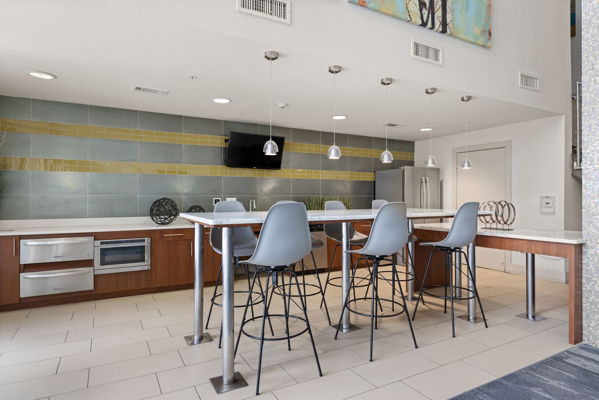 Modern kitchen with a large island, bar stools, and stainless-steel appliances at Sabina in Austin, TX.