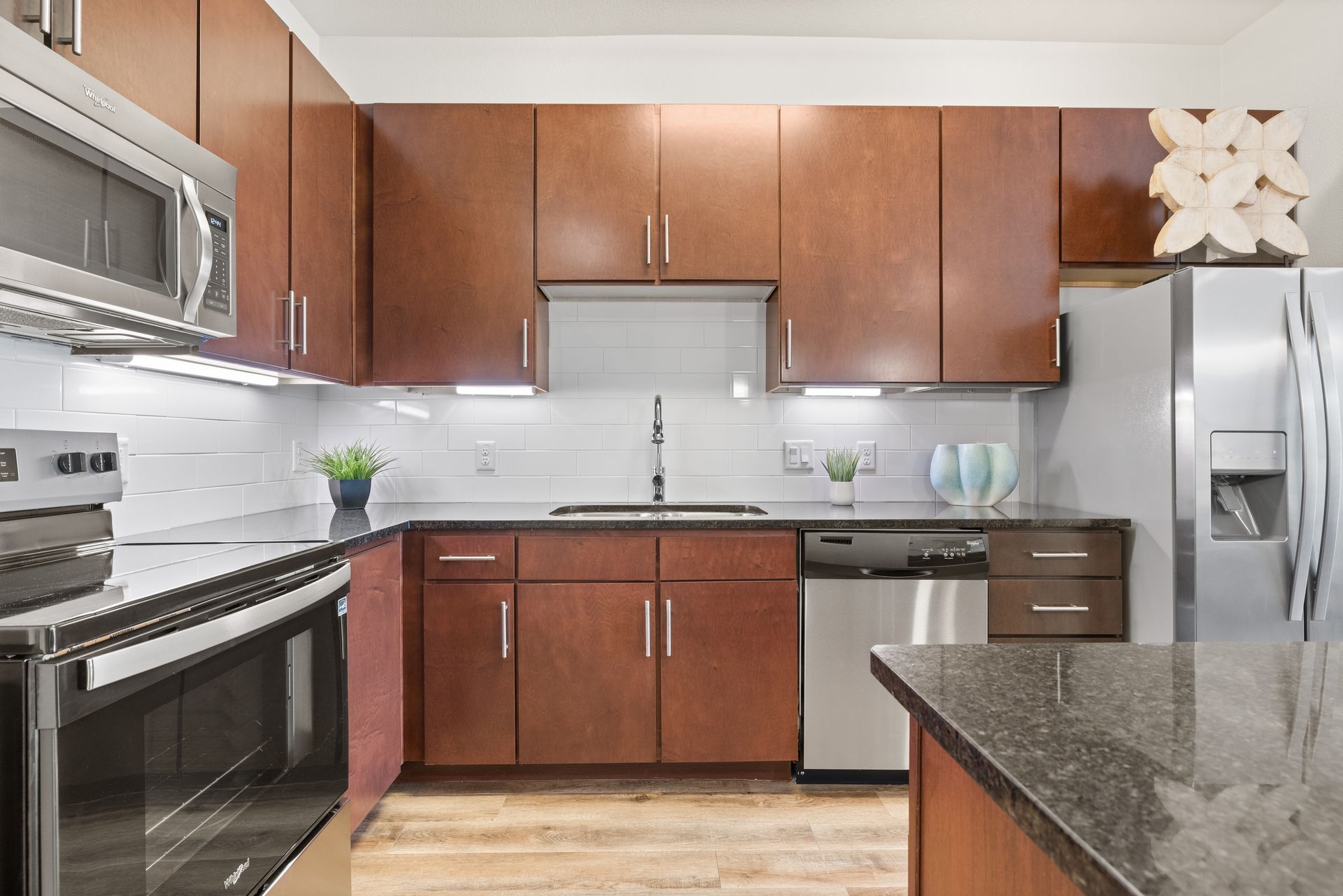 Modern kitchen with wood cabinets, stainless steel appliances, and granite countertops at Sabina in Austin, TX.