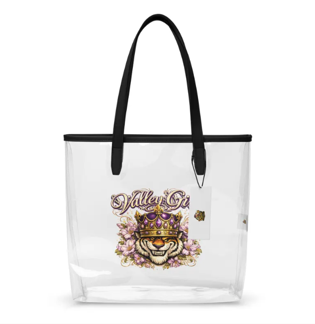 A clear tote bag with black handles, featuring a central graphic of a tiger wearing a crown amidst floral accents.