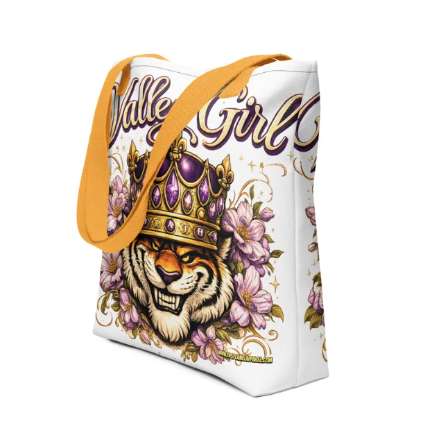 A white tote bag featuring a cartoon tiger wearing a purple crown surrounded by pink flowers and the text
