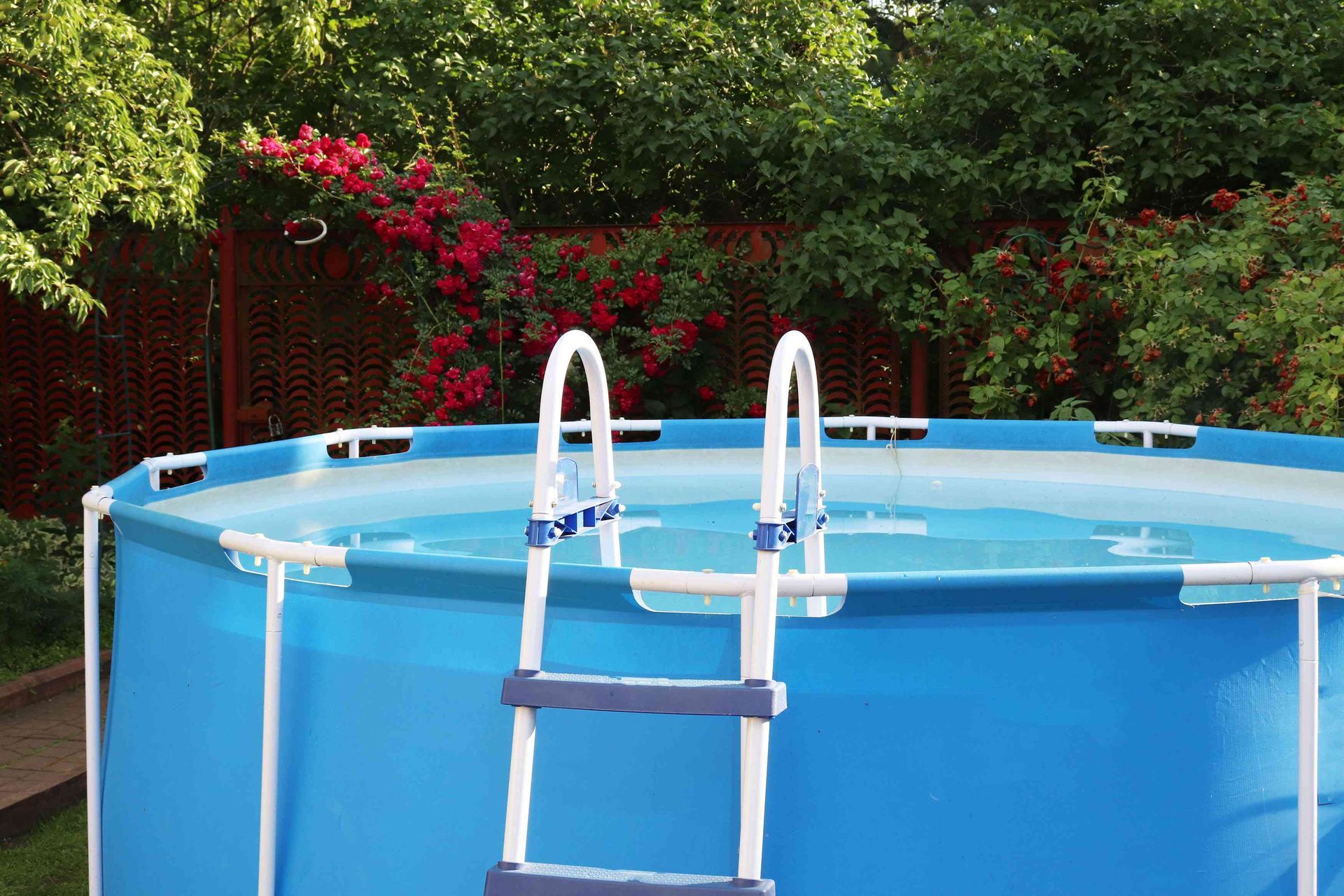 A blue swimming pool with a ladder attached to it.