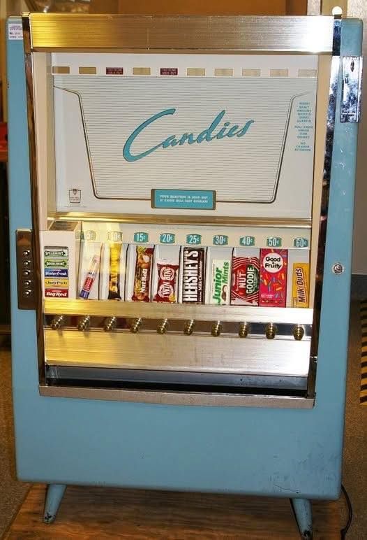 Vintage blue candy vending machine with selection of candy bars.