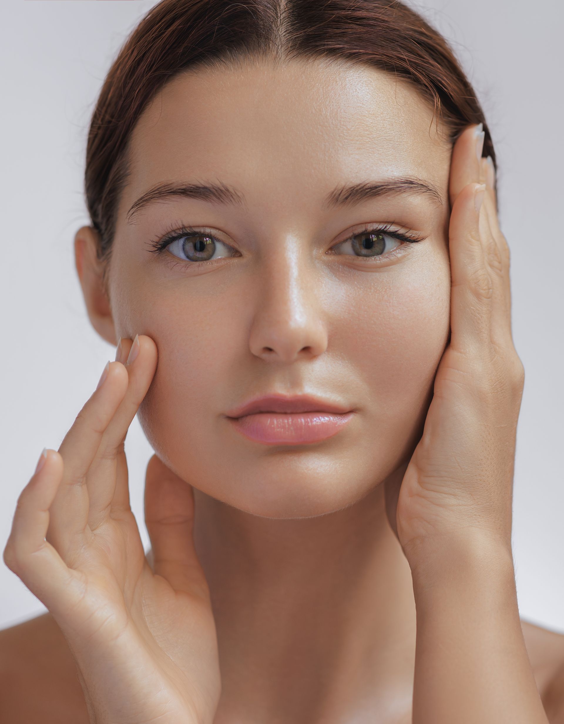 A close up of a woman 's face with her hands on it.
