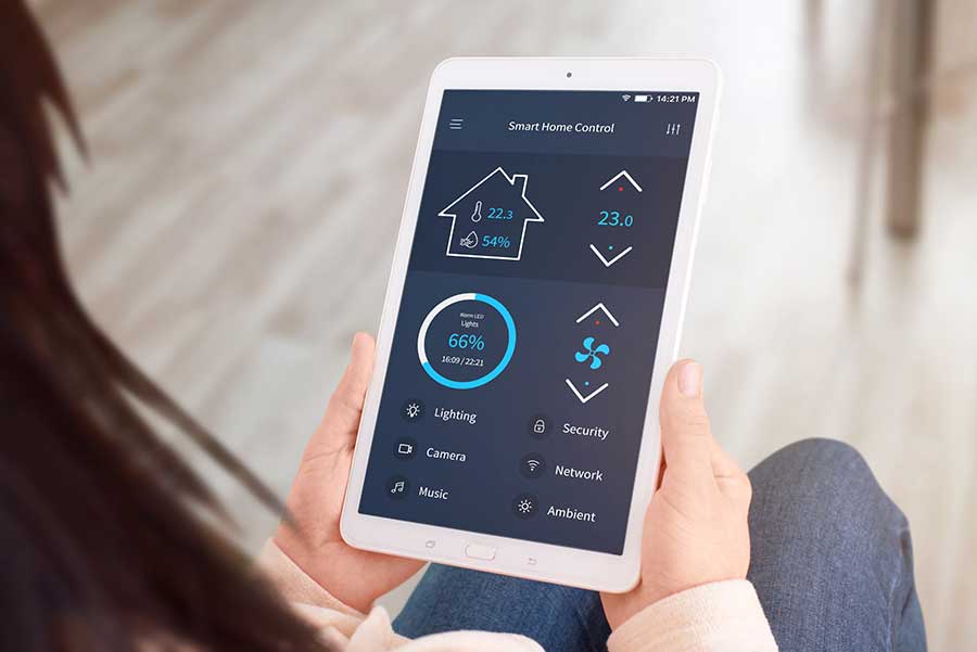 Persona che tiene in mano un tablet che mostra un'interfaccia di controllo della casa intelligente.