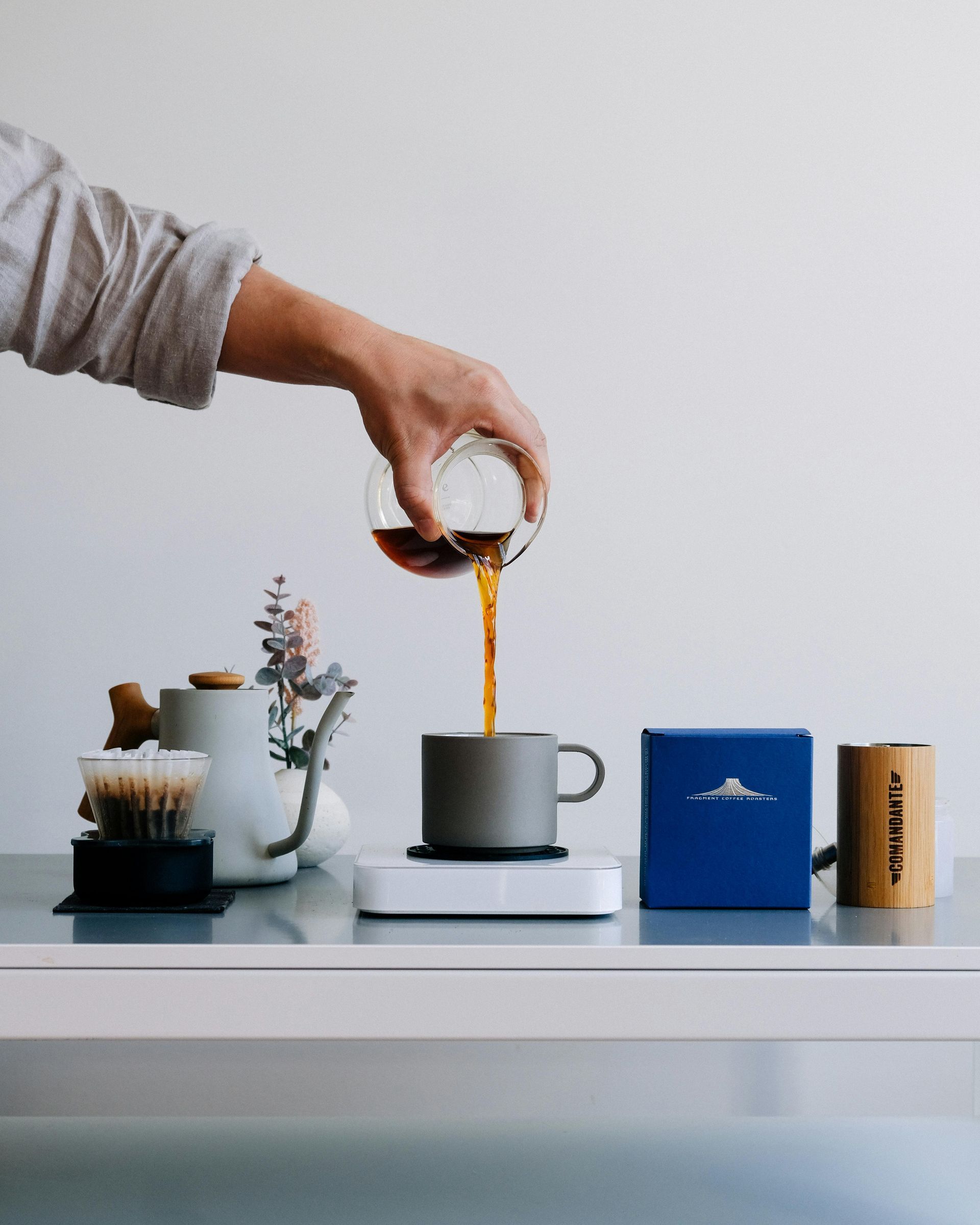 A person is pouring coffee into a cup on a table