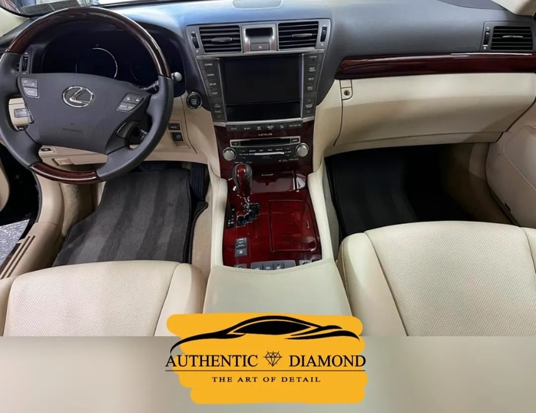 Interior of a Lexus, featuring wood trim, beige leather seats, and a central console.