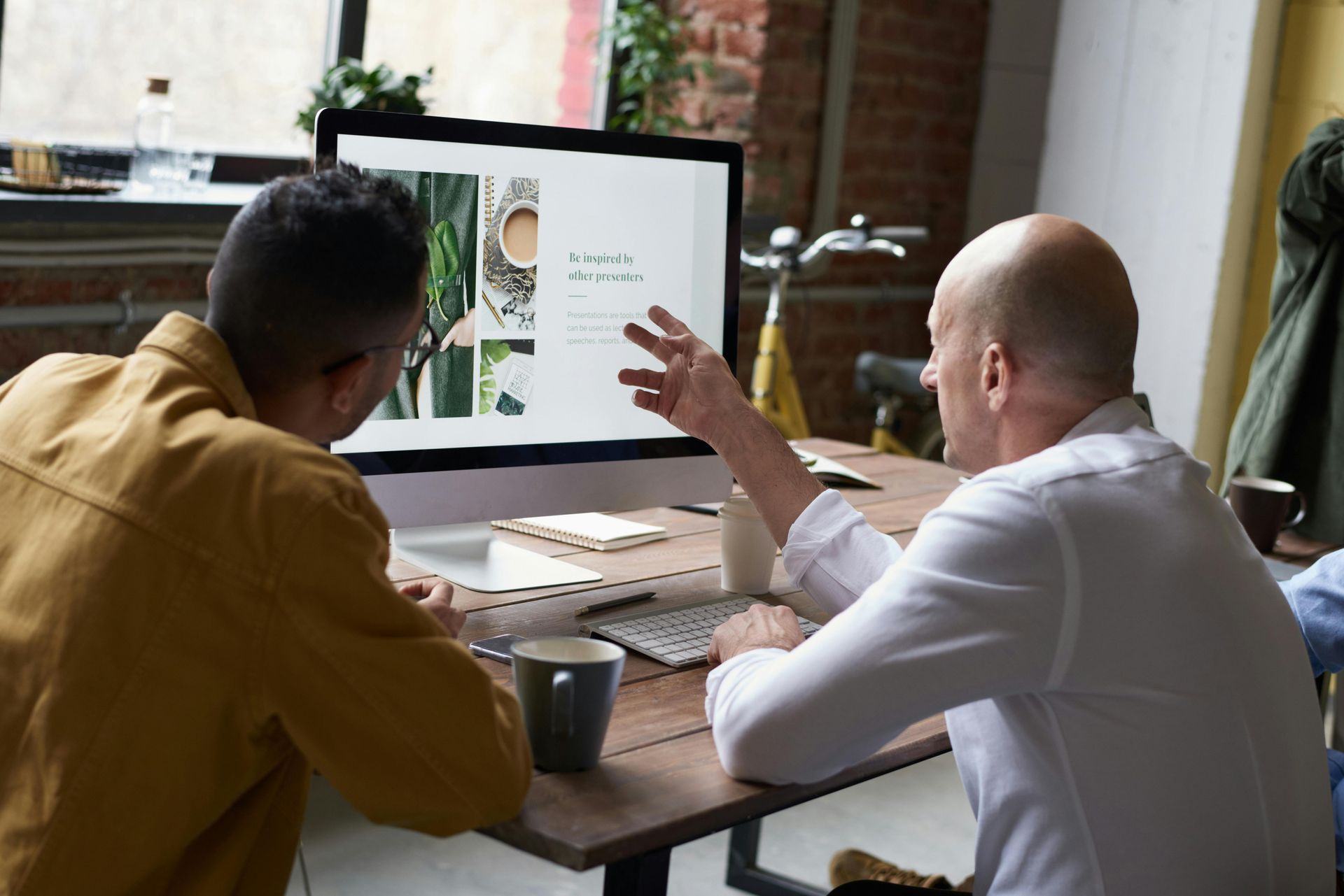 Houston business owner reviewing managed IT services benefits on computer with IT consultant nearby