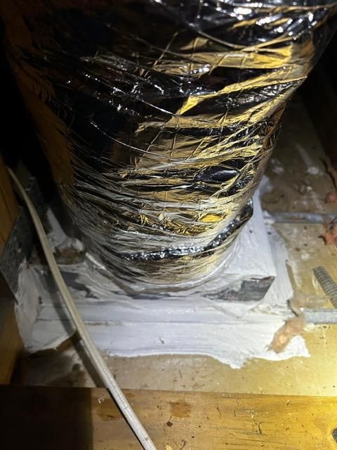 A close up of a duct in an attic.