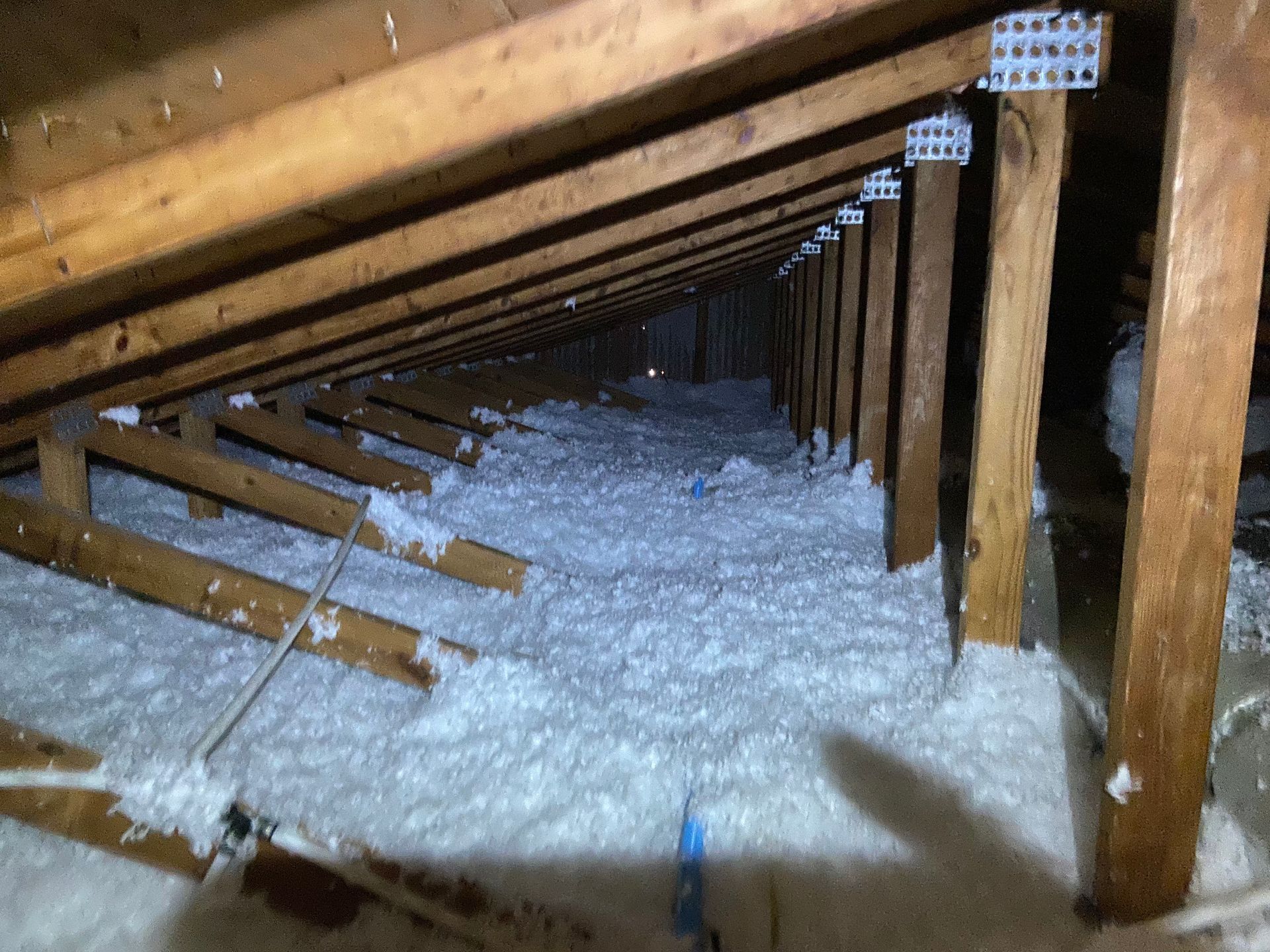 There is a lot of insulation in the attic of a house.