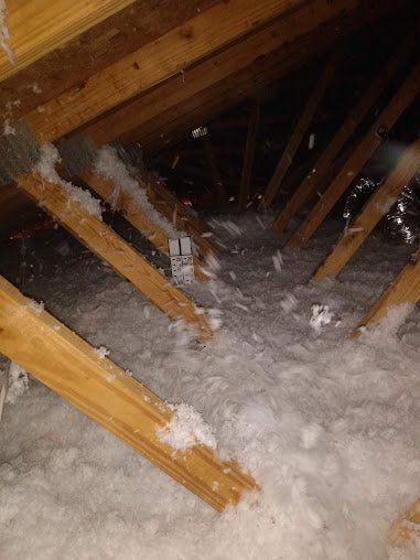 There is a lot of insulation in the attic of a house.