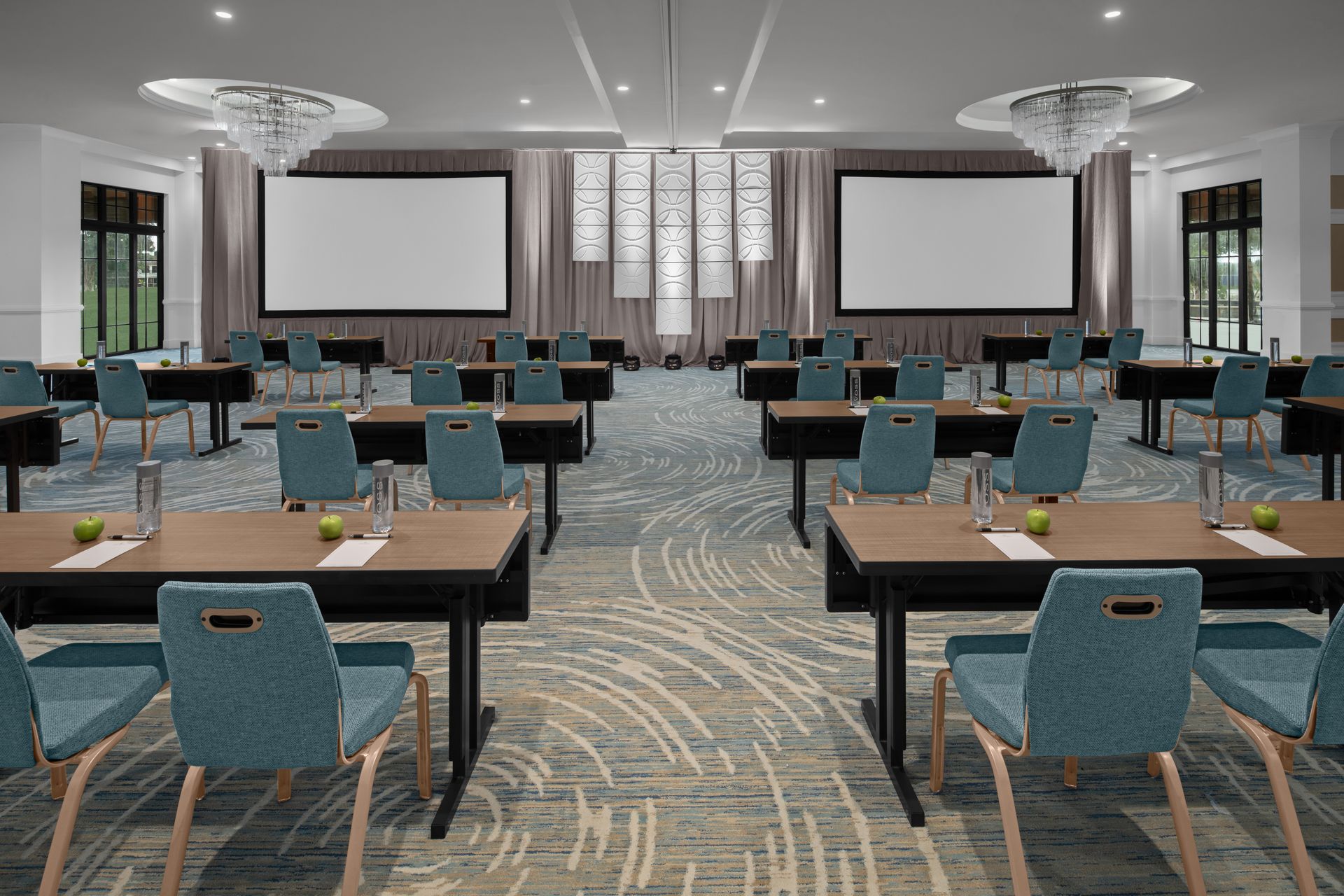 Our Story A large conference room with tables and chairs and a large screen.