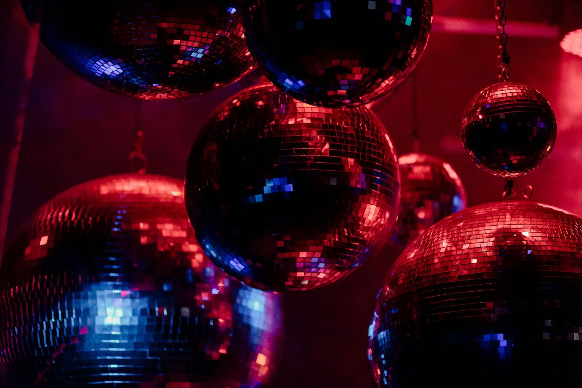 A group of disco balls are sitting on top of each other in a dark room.