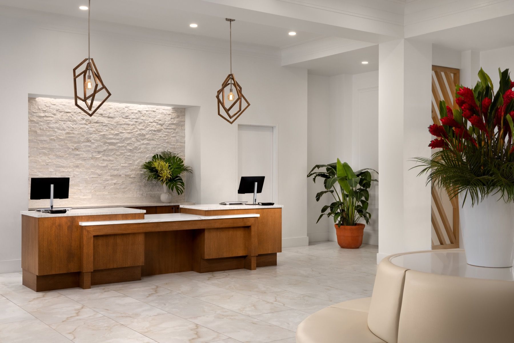 A hotel lobby with a reception desk and a couch.