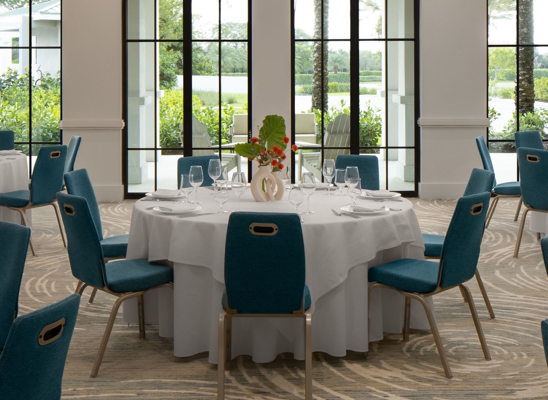 A large conference room with tables and chairs and a projector screen.