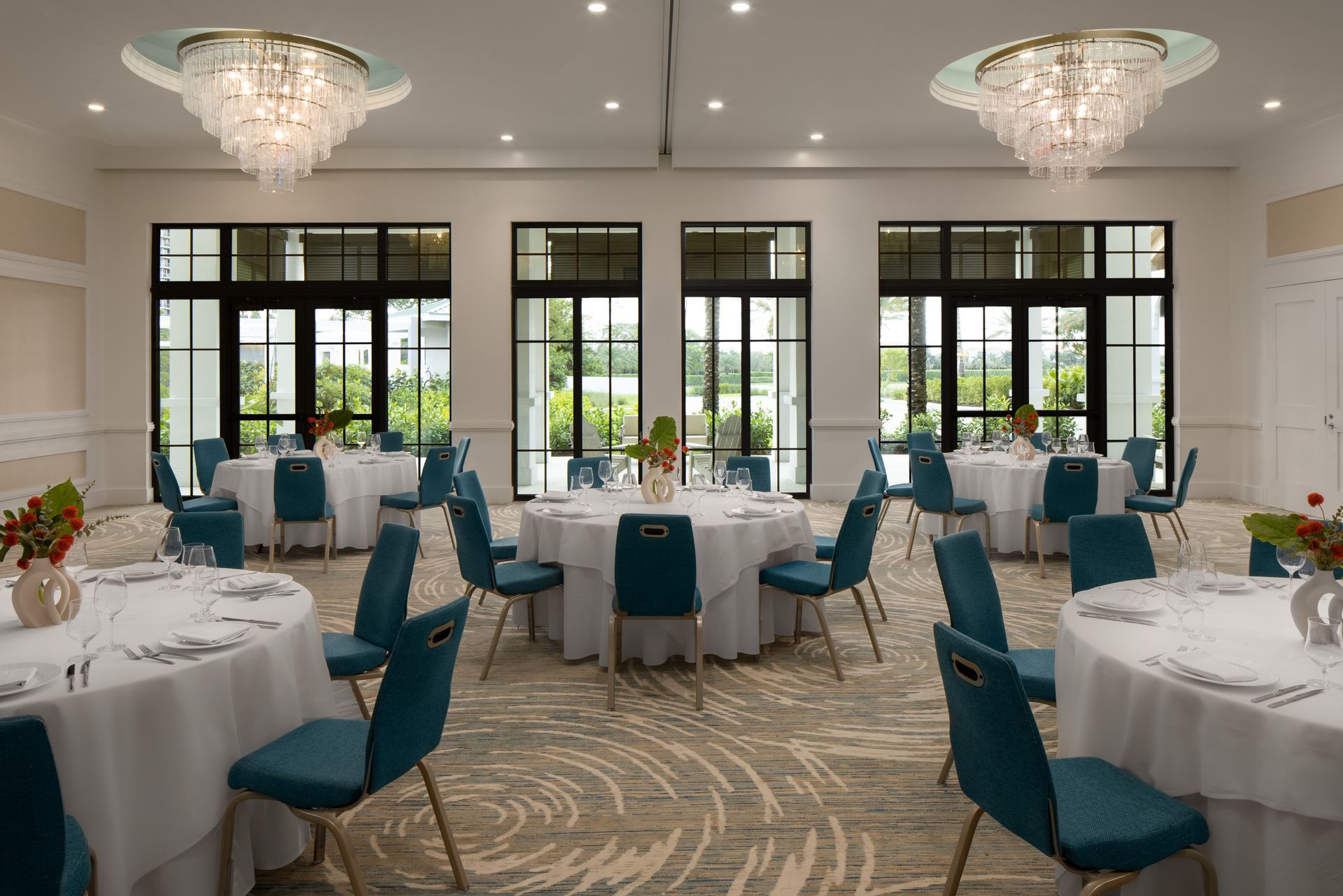 A large room filled with tables and chairs and a chandelier.