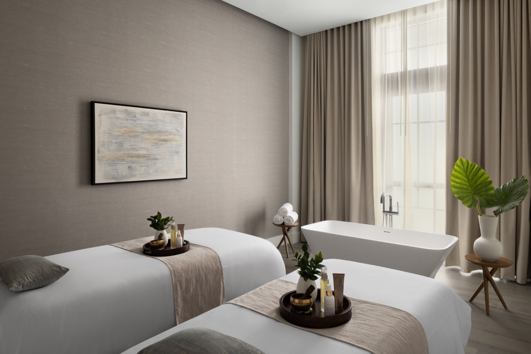 A hotel room with two beds and a bathtub.