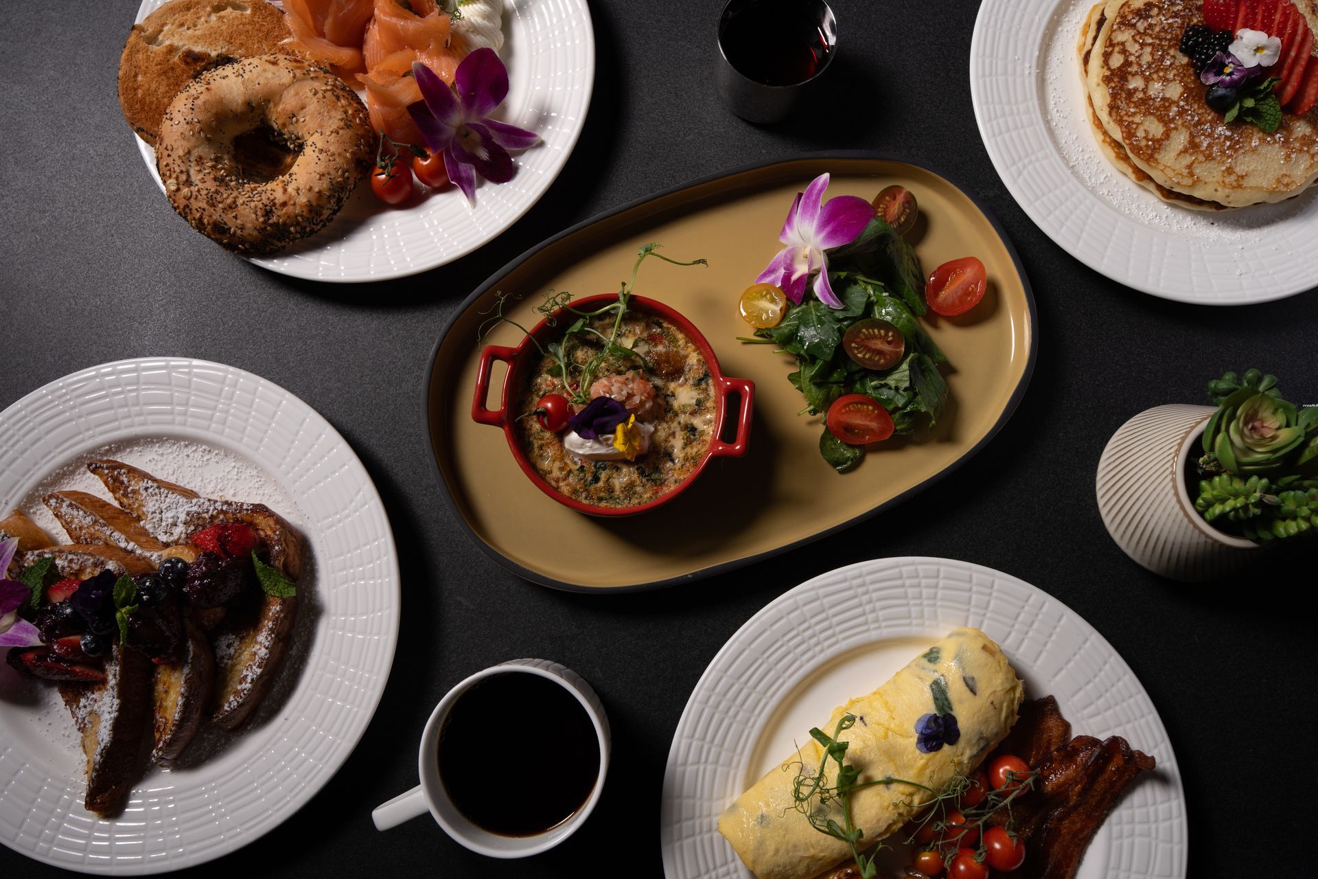 A table topped with plates of food and a cup of coffee