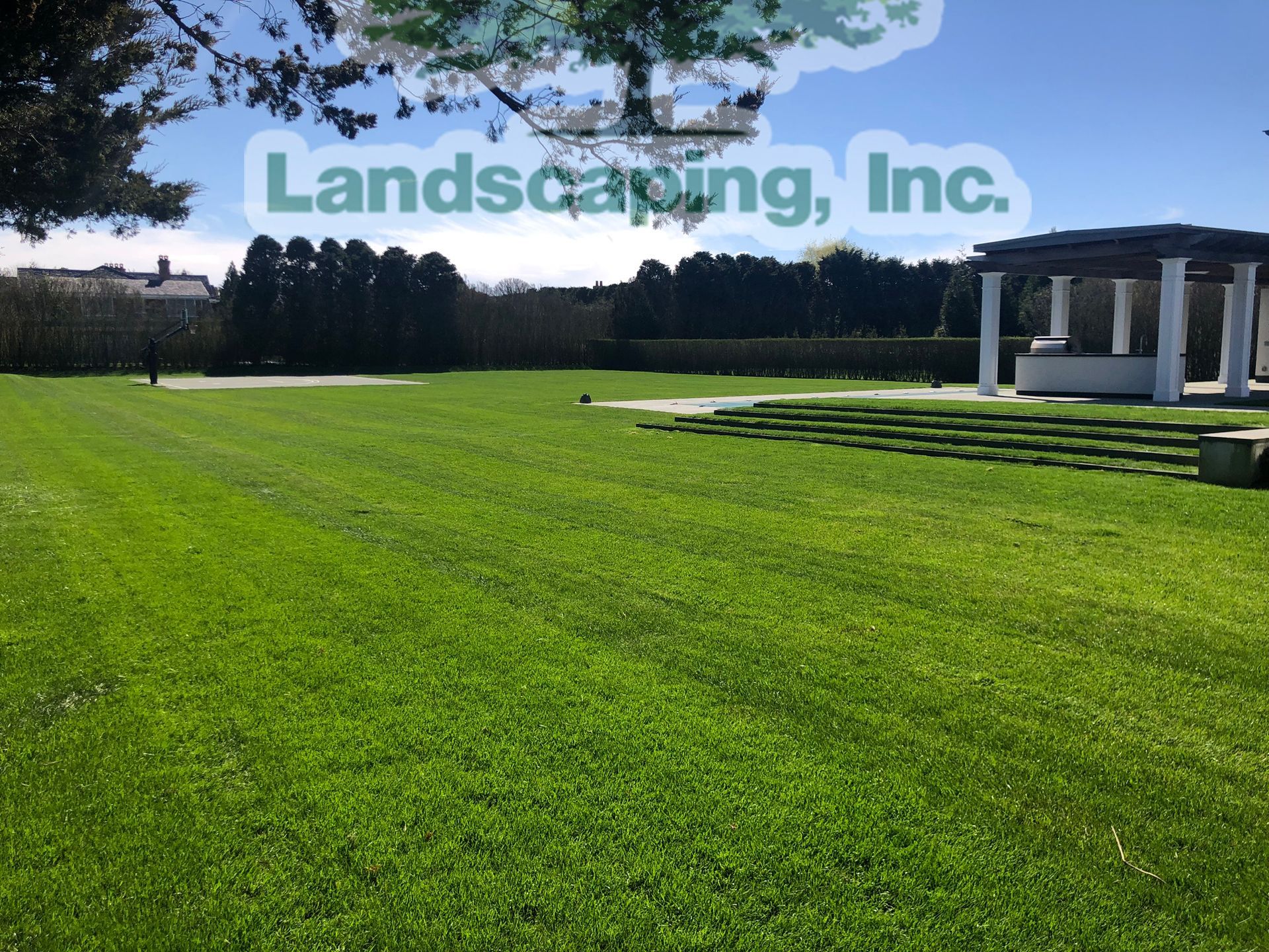 Green lawn with a white gazebo, under a blue sky. 