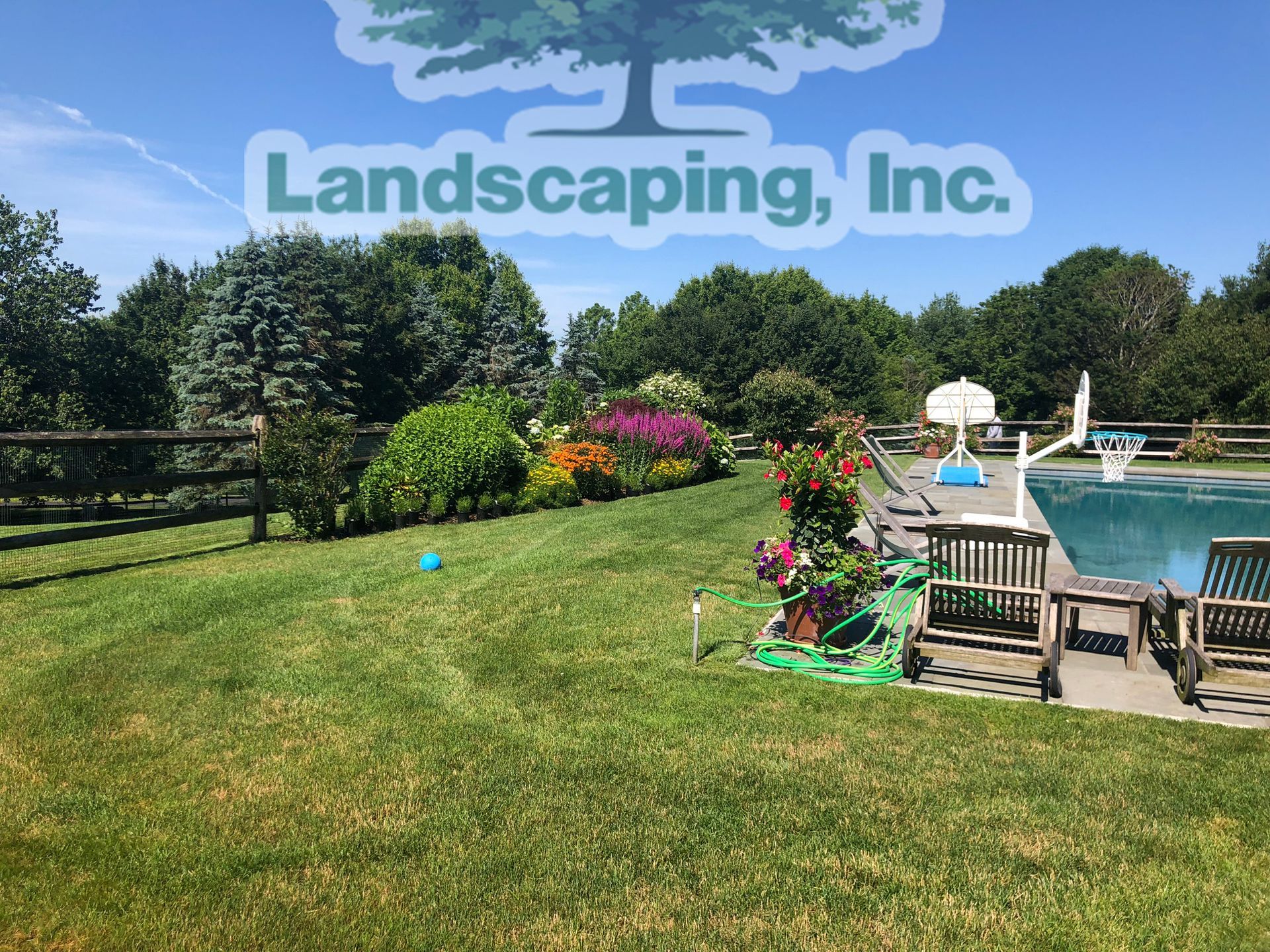 Green lawn with flower beds, pool, and trees under a blue sky. Landscaping Inc. logo.