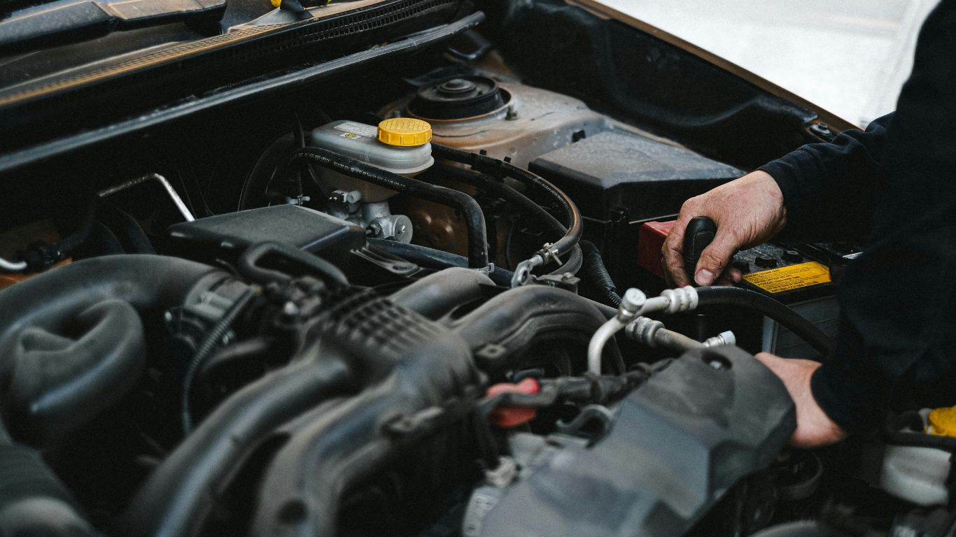 Person using a wrench to repair a car engine in the engine bay