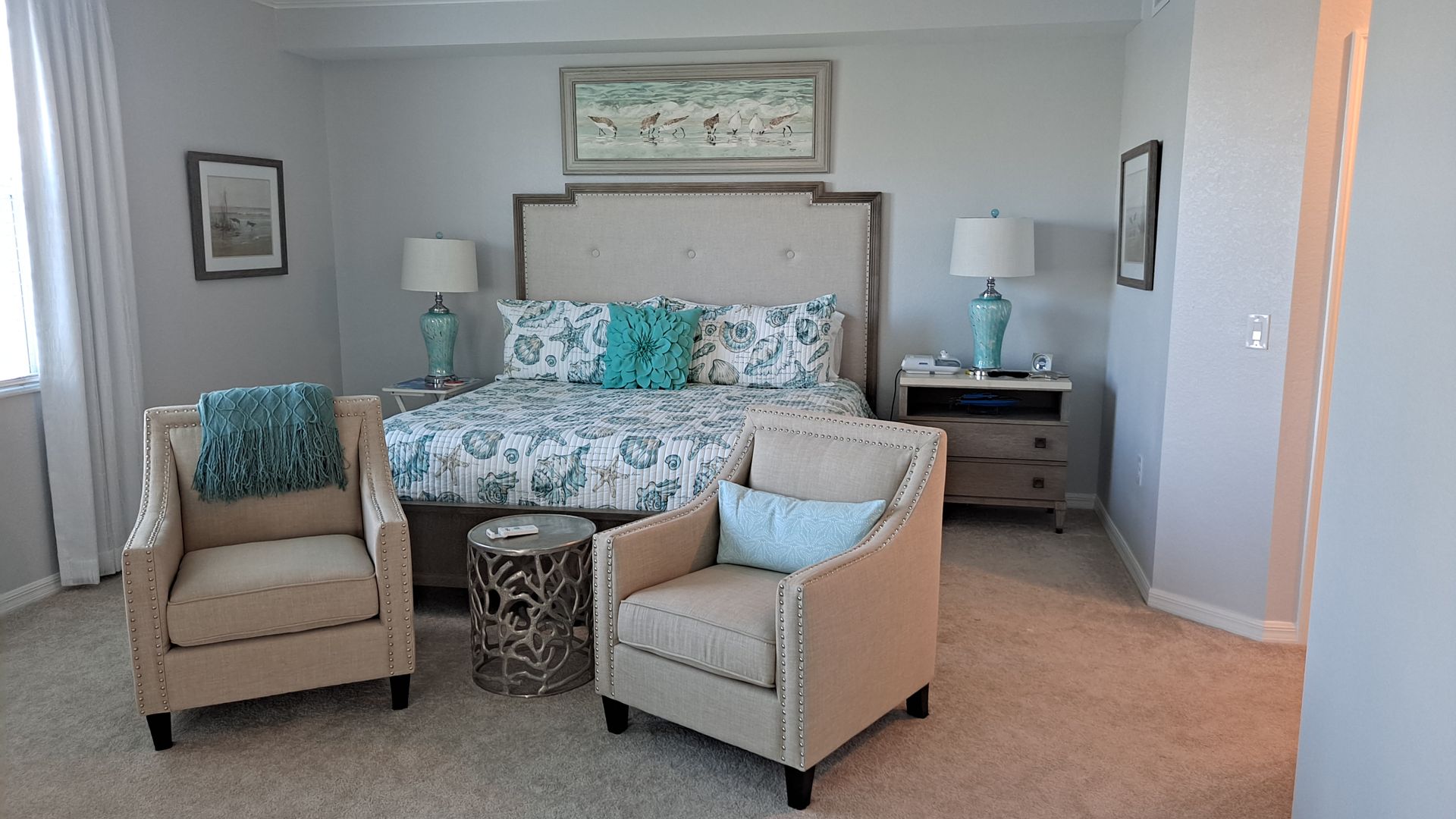 Person wearing yellow and blue gloves cleaning a white stove top with a blue cloth.