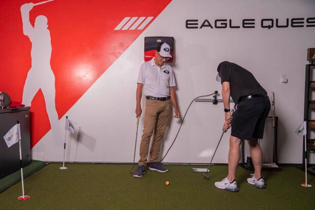 A Man Is Kneeling On The Floor Working On An Electrical Outlet