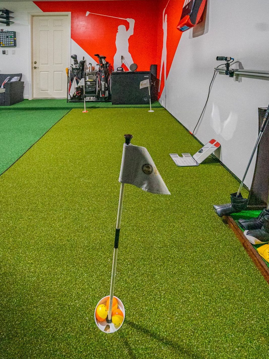 A room with a putting green and golf balls on it