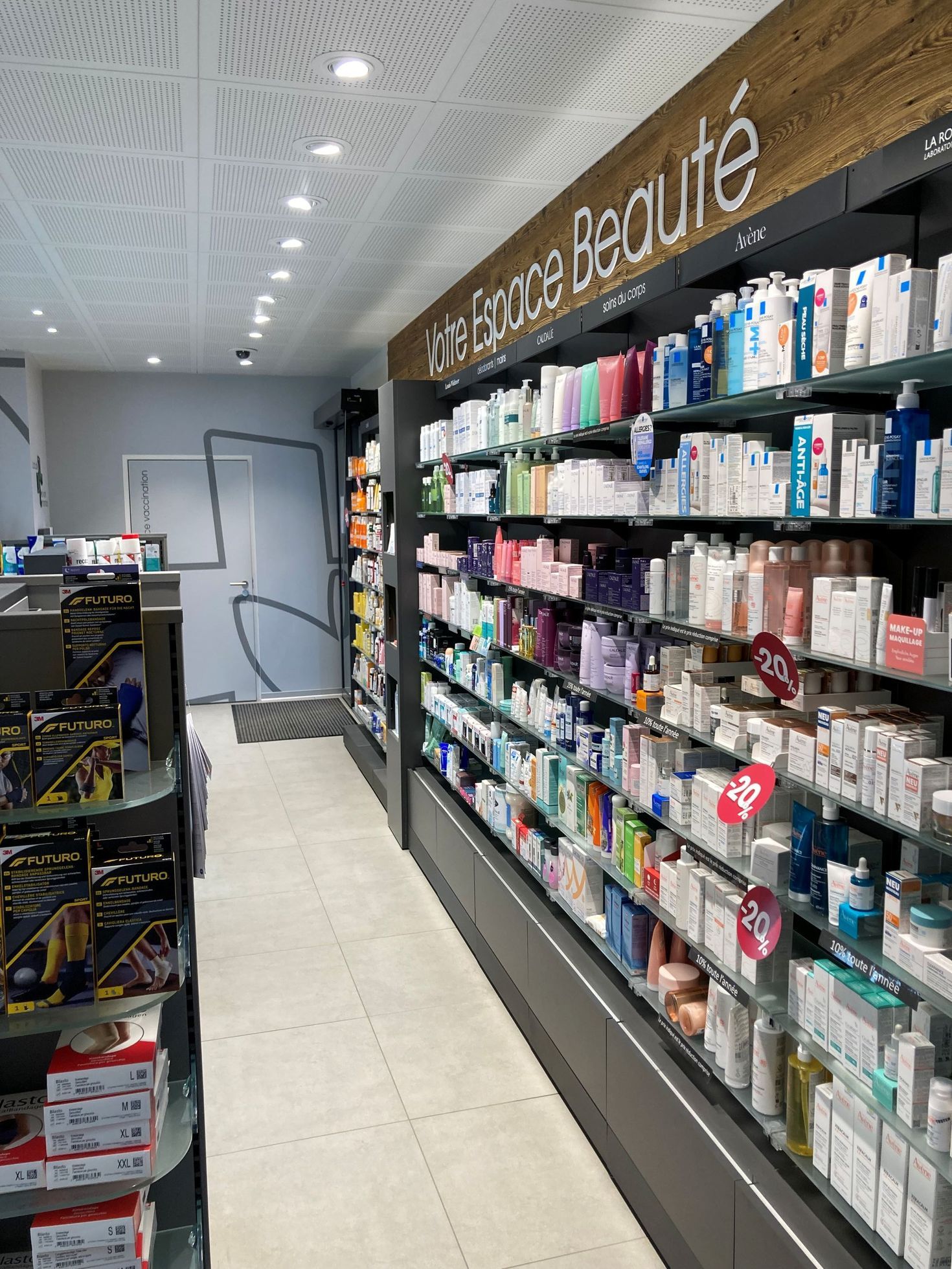 Ein heller Apothekengang mit der Aufschrift „Votre Espace Beauté“ mit Regalen voller Hautpflege- und Schönheitsprodukte.