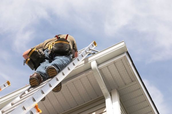 Seattle Handyman Services repairing the roof on a ladder