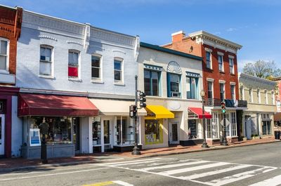 Row of Traditional American Brick Buildings with Colourful Shops under Blue Sky