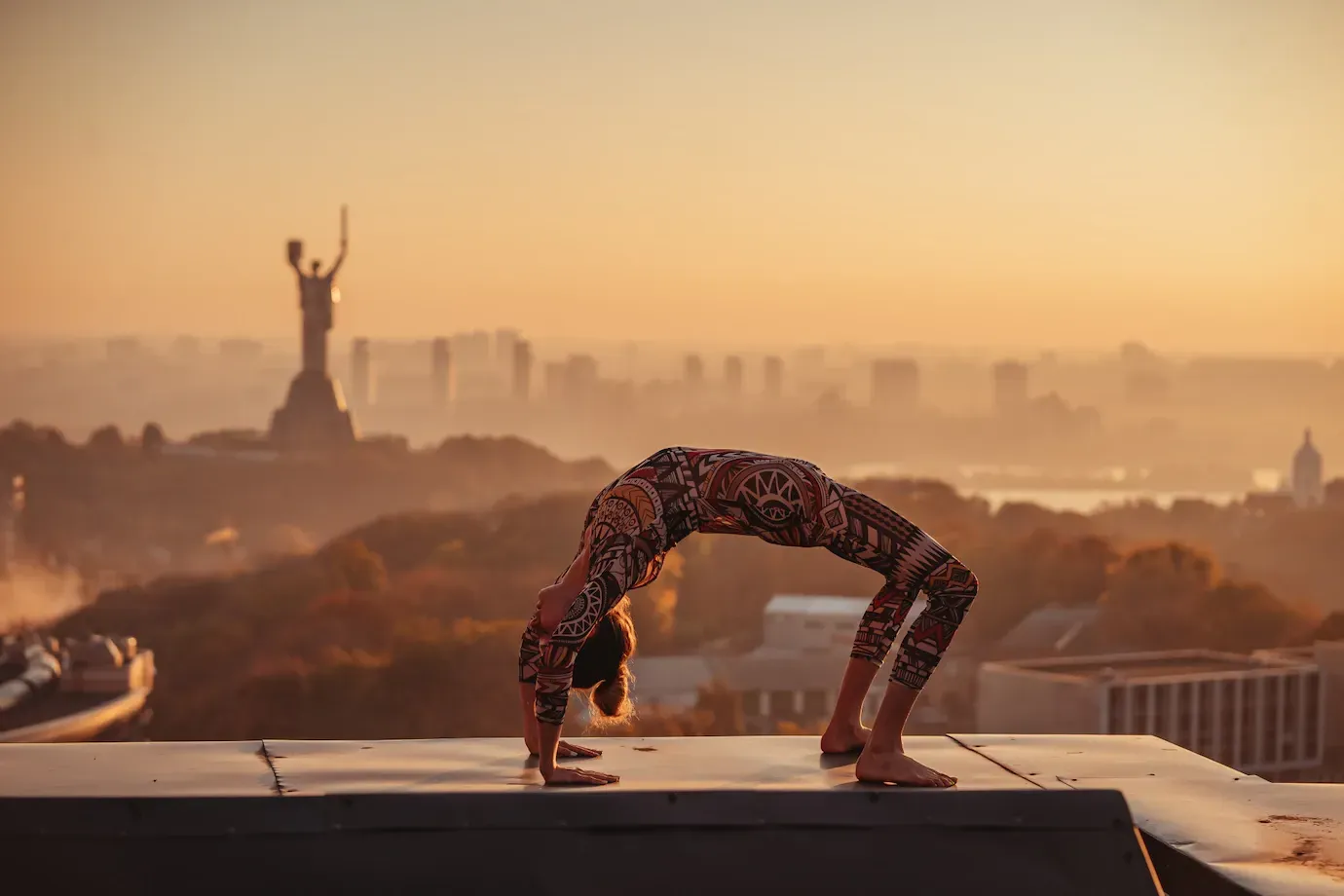 una mujer hace una pose de yoga en el techo de un edificio