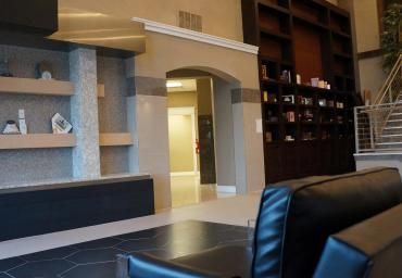 A living room with a couch and chairs and shelves