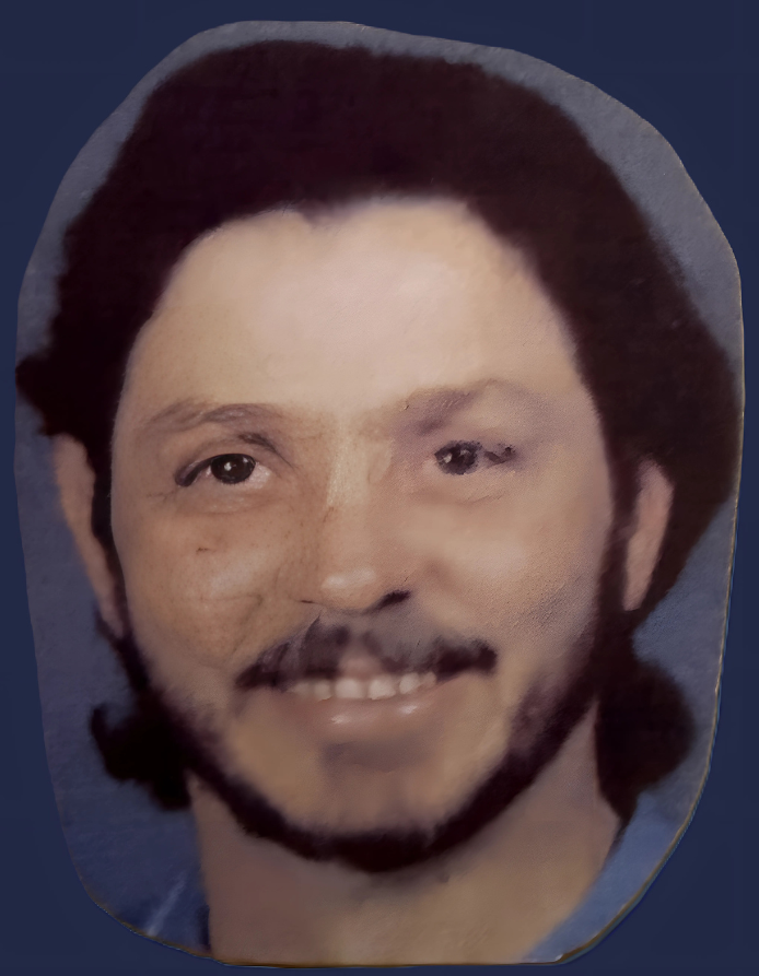 Man with dark hair and beard smiling.