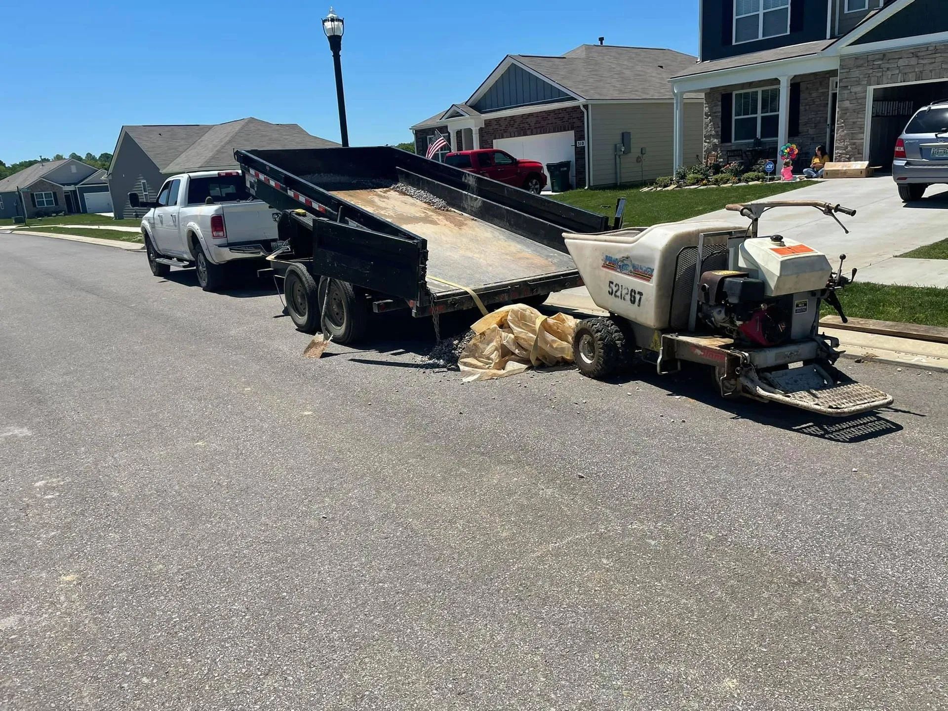 A truck with a trailer attached to it is parked on the side of the road.
