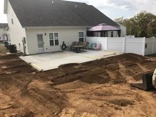 A house with a patio and a purple umbrella in the backyard.