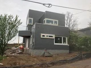 A large gray house with a lot of windows is being built.