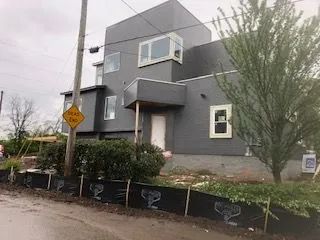 A large house is being built next to a road.