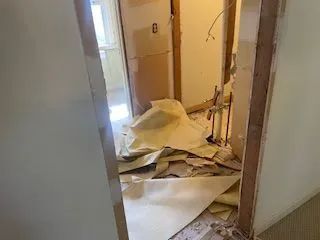 A room with a lot of papers on the floor and a door.